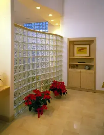 Curved glass block wall beside built-in cabinets