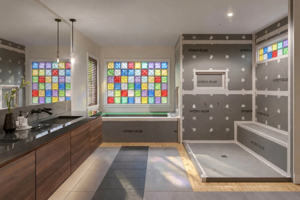 Bathroom with a colored glass block window over the tub and a HydroBlok shower, bench and niche ready to tile